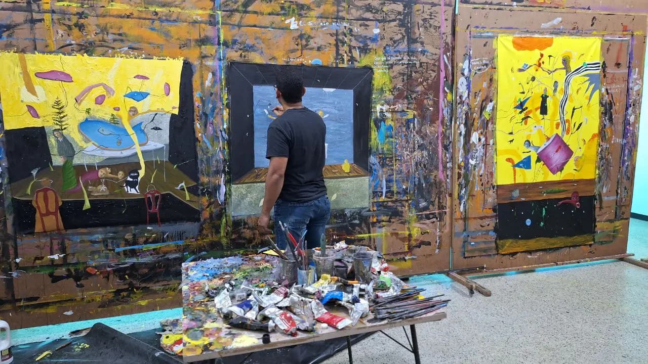 Johan Galué painting in his studio, among large-format works in yellow tones