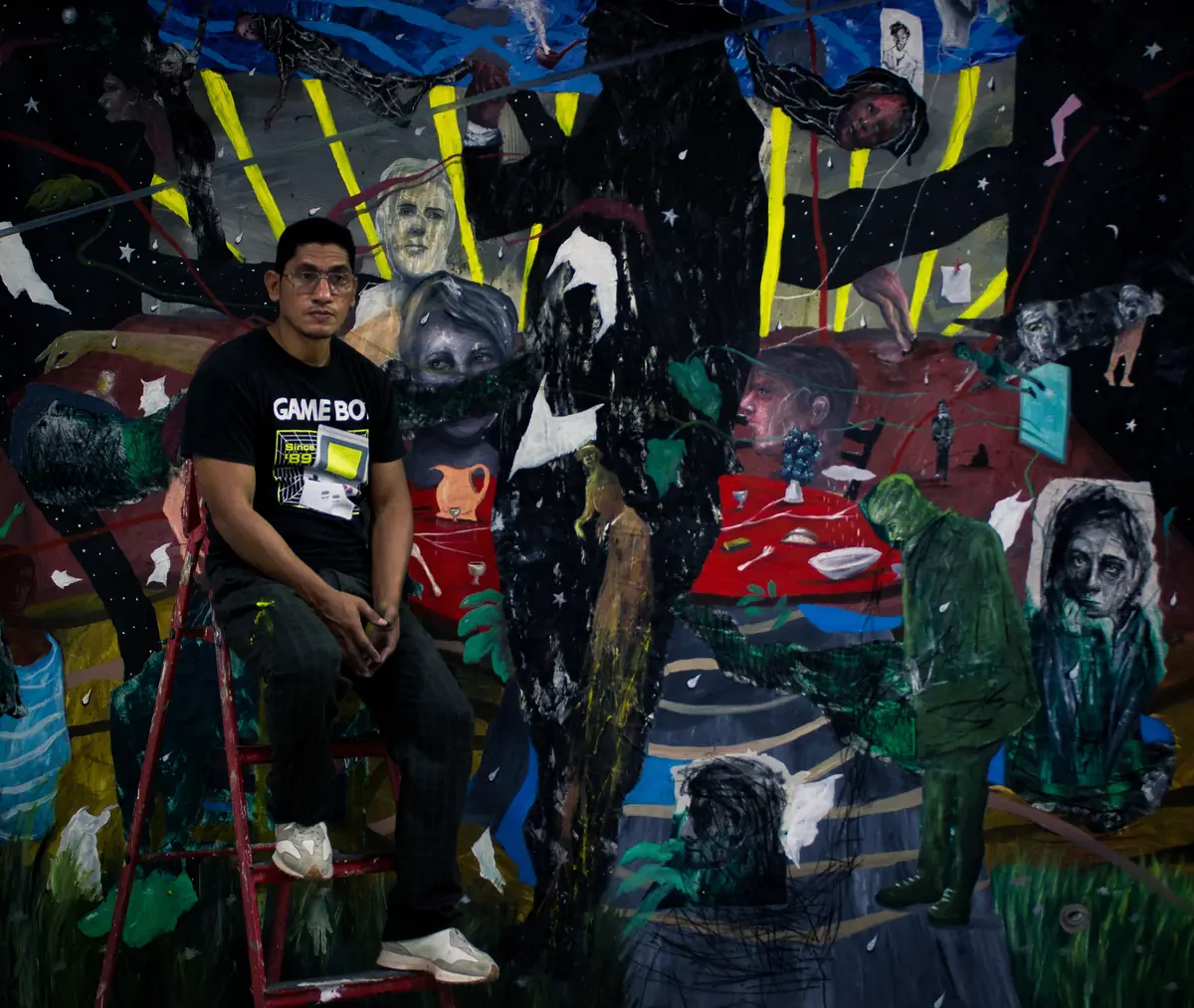 The artist seated among the works that fill his studio
